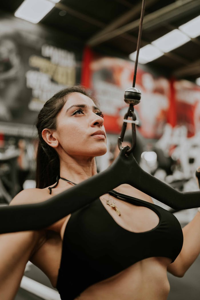 services-06 Portrait of a determined woman working out in a gym using fitness equipment.