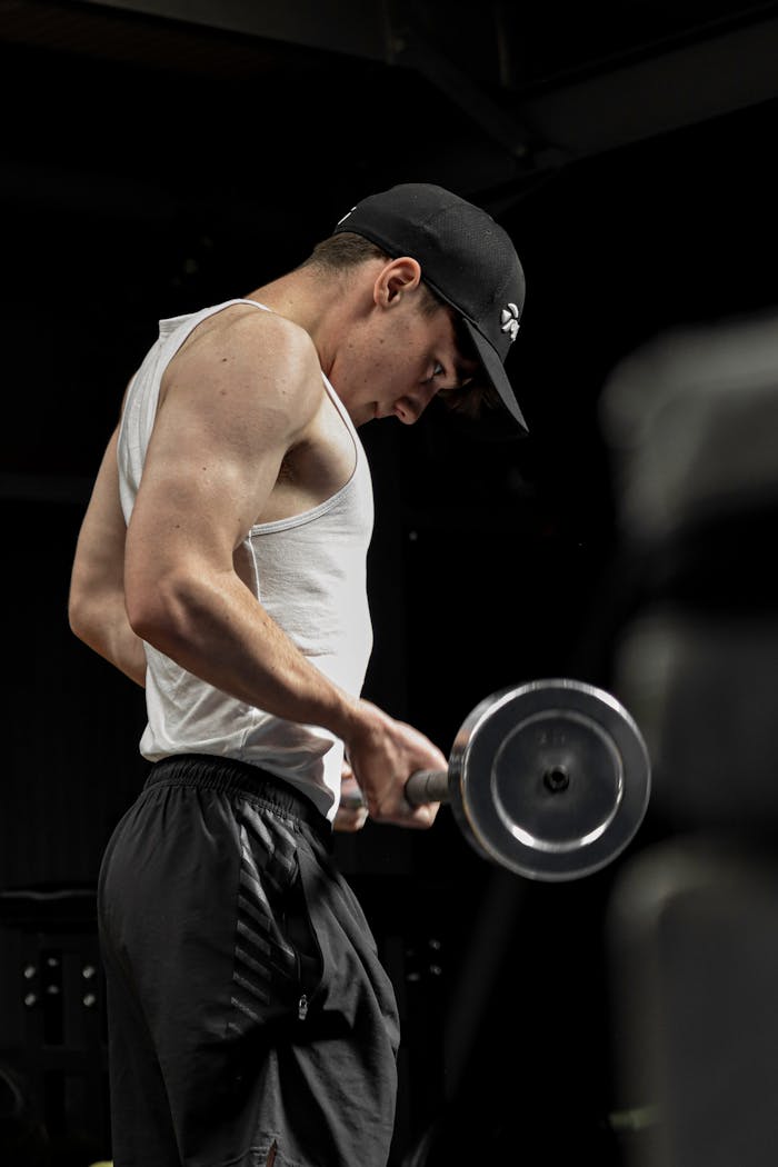 mission-02 Focused young man working out with dumbbells in the gym.